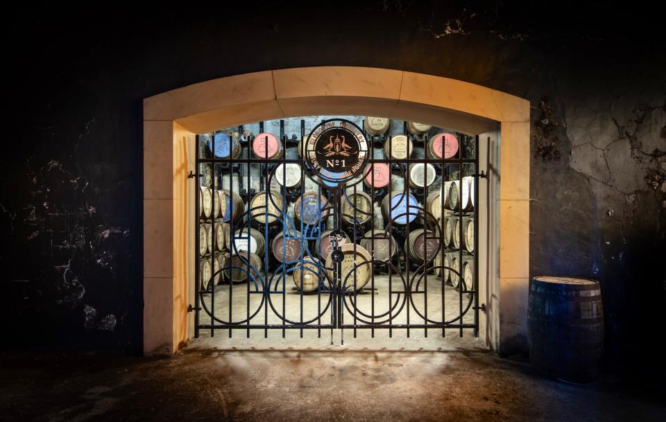 A metal gate in the maturation area with casks of Glengoyne whisky behind it